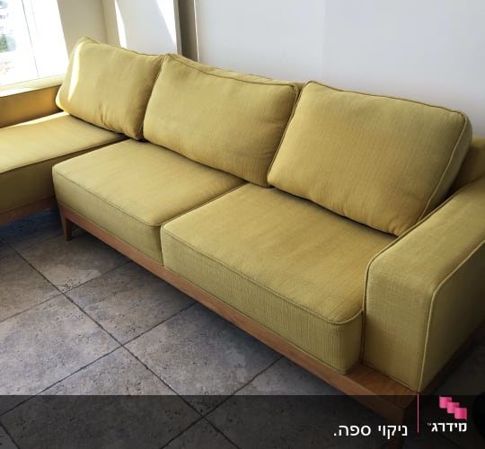 ספה צהובה עם כריות על רצפת אריחים